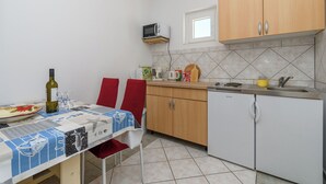 A compact kitchen with a microwave, sink, and a small refrigerator. - Apartments Mande (Rab)