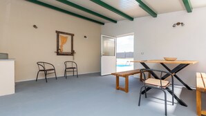 A room with a wooden table, two chairs, a bench, and a door leading outside. - House Mirakul Near Krka With Private Pool (Skradin)