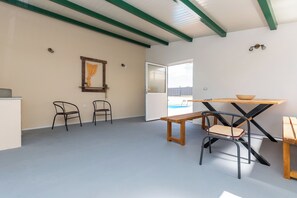A room with a wooden table, two chairs, a bench, and a door leading outside. - House Mirakul Near Krka With Private Pool (Skradin)