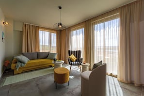 A living room with a sofa, armchairs, a coffee table, and a pendant light. - Apartments Menigo Manzoni (Punat)