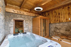 A wooden interior with a stone wall, a wooden cabinet, and a hot tub. - House Villa Lara (Vinodol)
