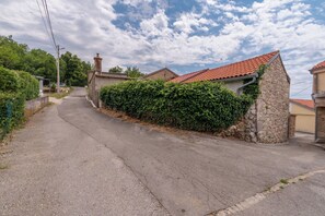 A narrow street with stone houses, a paved road, and a hedge. - House Villa Lara (Vinodol)