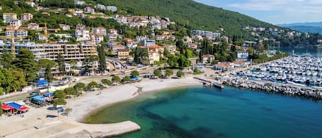 A coastal town with a marina, sandy beach, and residential buildings.