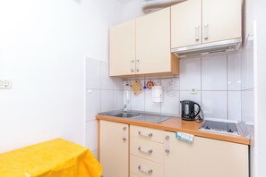 A compact kitchenette with a sink, a kettle, and a small countertop. - Apartment Sunny (Omis)