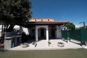 A building with a tiled roof, a covered patio area, and several planters with greenery. - House Vila Ana (Lopar)