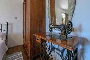 A vintage Singer sewing machine on a wooden table in a room with a bed and a wooden wardrobe. - House Vila Ana (Lopar)