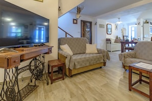 A living room with a television, sofa, and wooden furniture. - House Vila Ana (Lopar)