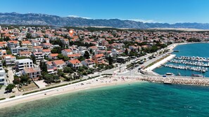 Eine Küstenstadt mit Wohngebäuden, einem Yachthafen und einem Strand.