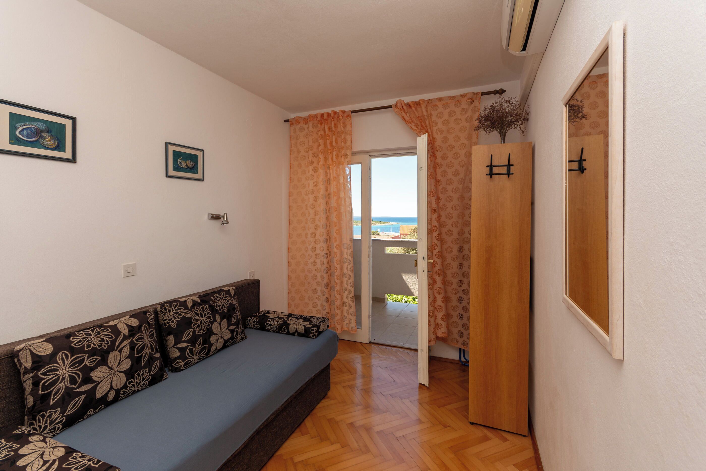 Une pièce avec un canapé, une porte en bois et une vue à travers une porte vitrée.