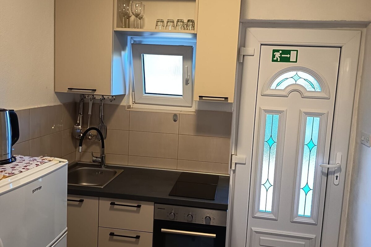 A compact kitchen with a built-in oven, a microwave, and a sink.