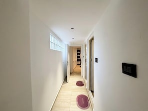 A hallway with a light-colored floor, a window on the left, and a door on the right. - House Holiday House Art (Crikvenica)