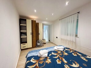 A bedroom with a bed, a wardrobe, a fan, and a window with curtains. - House Holiday House Art (Crikvenica)