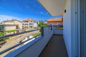 A balcony with a clear view of neighboring buildings and a street. - Apartment Evelin (Crikvenica)