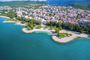 An aerial view of a coastal town with buildings, beaches, and clear blue waters. - Apartment Evelin (Crikvenica)