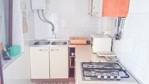 Eine Küche mit Gaskochfeld, doppelter Spüle und einer Mikrowelle.