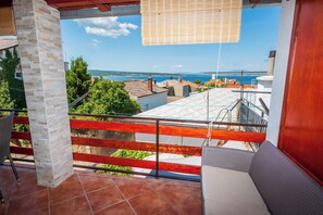 Ein Balkon mit Blick auf das Meer und die Gebäude.
