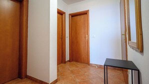 A hallway with wooden doors and a tiled floor. - Apartment Ines (Novi Vinodolski)