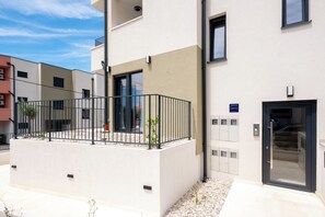 A modern building with a balcony, a door, and a sign indicating 'Guest Room.' - Apartment Seaview Terrace (Podstrana)