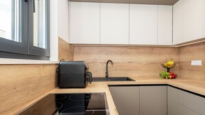 Une cuisine moderne dotée d’une cuisinière intégrée, d’un évier et d’un pare-feu en bois.