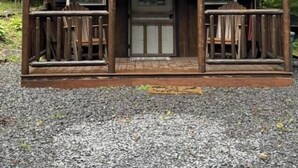 Eine Holzhütte mit Veranda, zwei Fenstern und einer Tür.