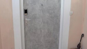 A closed door with a handle and a lock, a small window, and a door frame. - Apartment Nikola Centar (Biograd na Moru)