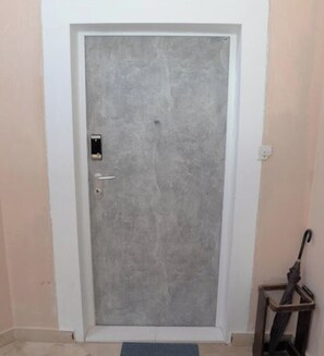 A closed door with a handle and a lock, a small window, and a door frame. - Apartment Nikola Centar (Biograd na Moru)