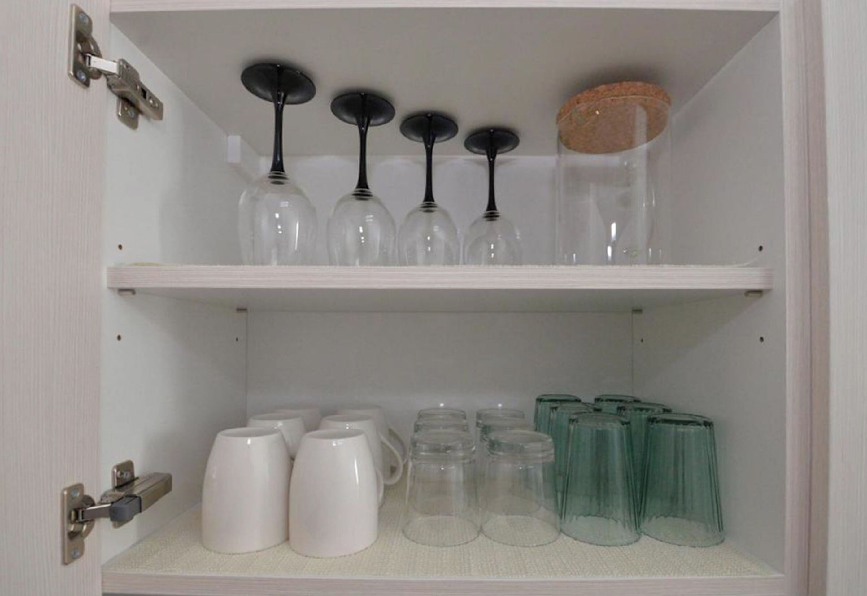 Un mueble aparador con copas de vino y vasos.