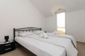 Une chambre à coucher avec un lit, une table de chevet, une lampe et une fenêtre.