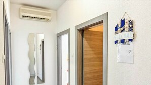 A hallway with a wooden door, a mirror, and a welcome sign with a username and password. - Apartment Franky (Crikvenica)