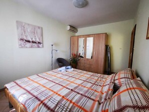 A bedroom with a bed, a wardrobe, a mirror, and a painting on the wall. - Apartments Sepcevic (Murter-Kornati)