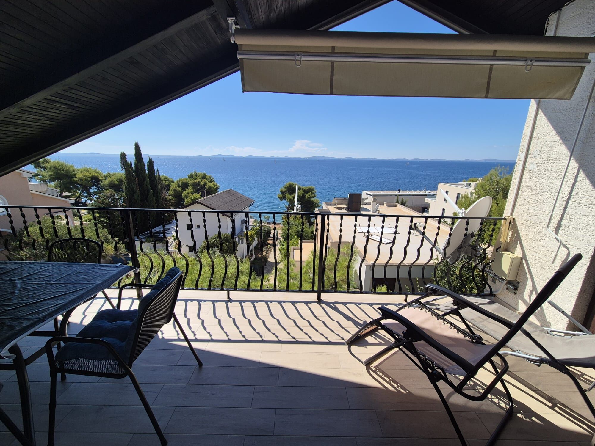 Ein Balkon mit Meerblick, einem Tisch und Stühlen.