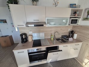 A modern kitchen with a microwave, coffee maker, and dishwasher. - Apartments Sepcevic (Murter-Kornati)