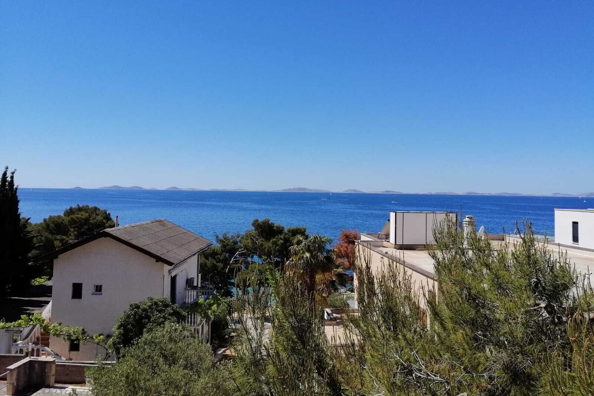 Ein Küstenwohngebiet mit Häusern und freiem Blick auf das Meer.