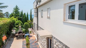 A building with a stone exterior, a window, and a view of the sea. - Apartment Nikol (Crikvenica)