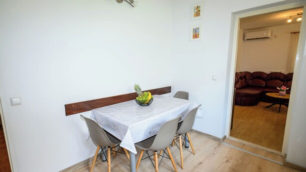 A dining area with a table, chairs, and a fruit bowl. - Apartment Nikol (Crikvenica)
