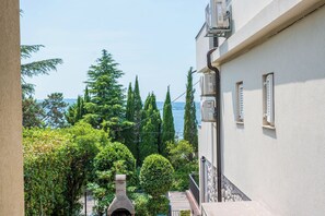 A building with a view of a body of water, surrounded by trees. - Apartment Nikol (Crikvenica)