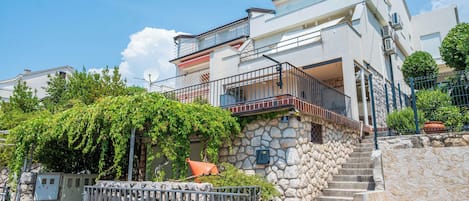 A multi-story building with a stone staircase leading to a balcony.