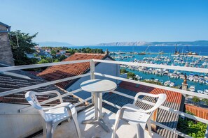 A balcony with a table and chairs overlooking a marina with boats. - House Arija (Novi Vinodolski)