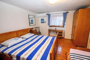 A bedroom with a bed, a desk, a chair, and a wardrobe. - House Arija (Novi Vinodolski)