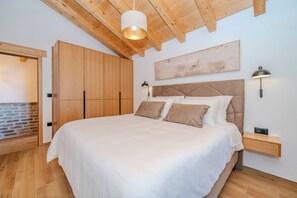 Ein Schlafzimmer mit einem Bett, einem Holzschrank und einer Wandleuchte.