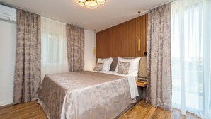 Een moderne slaapkamer met een groot bed, een wand van houten panelen en een plafondlamp.