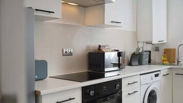 A modern kitchen with a built-in oven, microwave, and dishwasher.