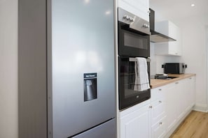 Eine moderne Küche mit einem Einbaukühlschrank, Backofen und einer Mikrowelle.