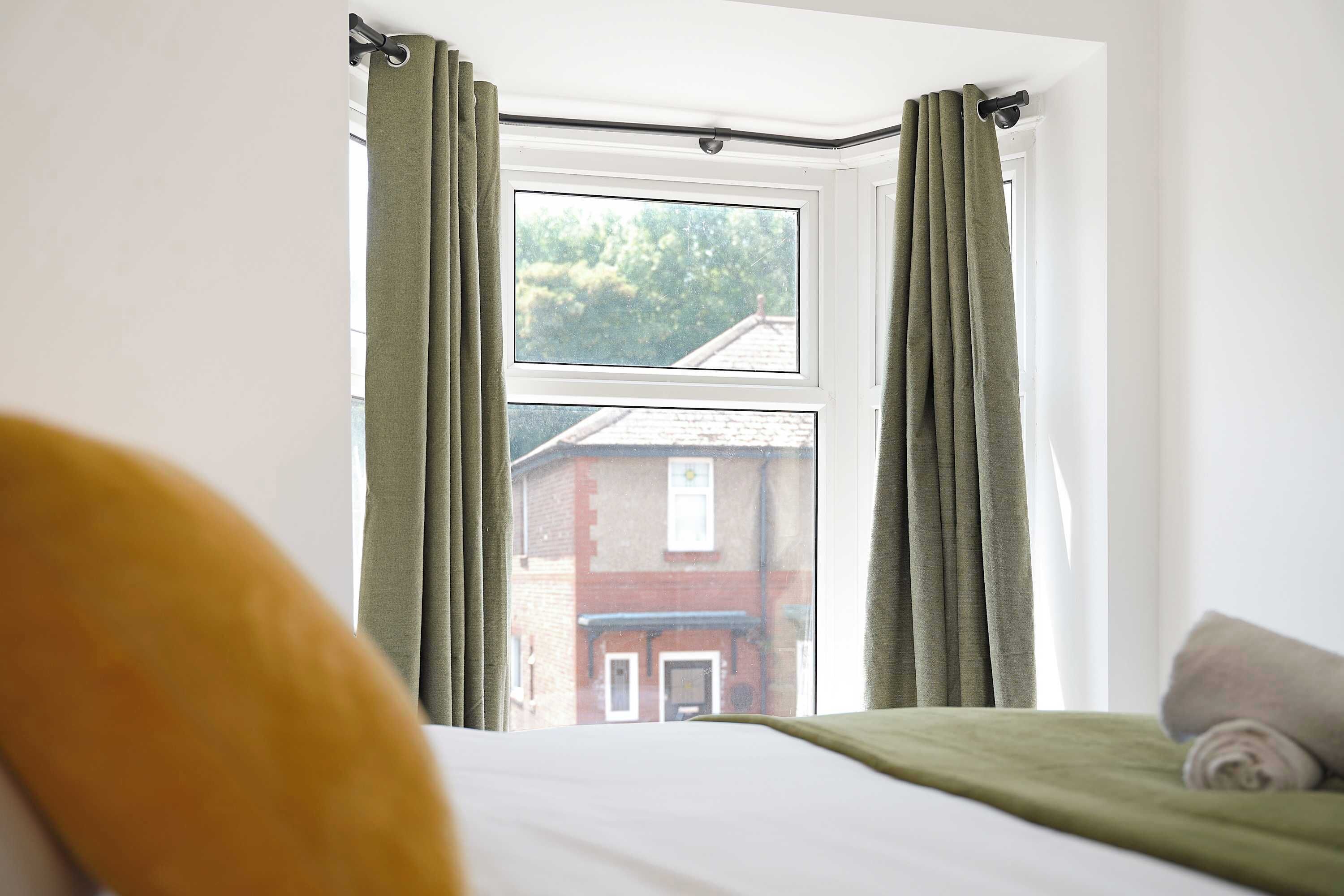 This bright and versatile bedroom can be arranged as either a double or twin room upon request. It features two bedside tables and a charming bay window that fills the space with natural light, creating a warm and inviting atmosphere.