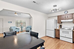 A modern kitchen with a refrigerator, stove, and wooden cabinets. - 🐾Ash at the Beach | Pet-Friendly Coastal Getaway w/ Sunroom & Bikes☀️ (Santa Rosa Beach)