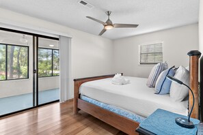 A bedroom with a bed, a ceiling fan, a window with blinds, and a bedside table with a lamp. - 🐾Ash at the Beach | Pet-Friendly Coastal Getaway w/ Sunroom & Bikes☀️ (Santa Rosa Beach)