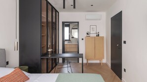 A modern bedroom with a bed, a desk, a wardrobe, and a mirror. - Villa Respiro Residence South (Kastela)