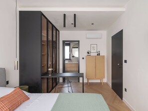 A modern bedroom with a bed, a desk, a wardrobe, and a mirror. - Villa Respiro Residence South (Kastela)