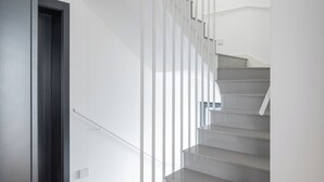 Eine moderne Treppe mit Holzboden und weißen Wänden.