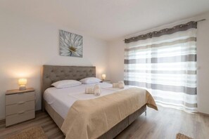 A bedroom with a bed, nightstands, a wall art piece, and a window with curtains. - Villa Zrilic With Private Pool (Benkovac)